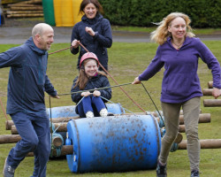 Family pulling a barrel together